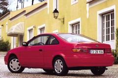 Sarkana Toyota Paseo 1996 no sāniem